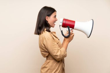 İzole edilmiş arka planda genç bir kız megafonla bağırıyor.