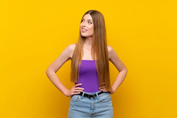 Jovem Mulher Sobre Fundo Amarelo Isolado Posando Com Braços Quadril — Fotografia de Stock