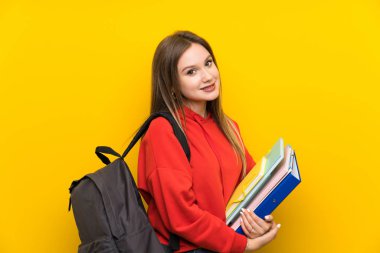 Sarı arka plan gülüyor üzerinde genç öğrenci kız