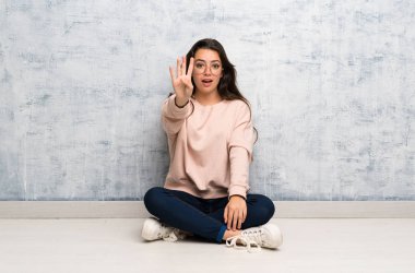 Genç öğrenci kız mutlu bir masada okuyan ve parmakları ile dört sayma