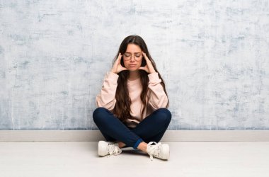 Baş ağrısı olan bir masada okuyan genç öğrenci kız