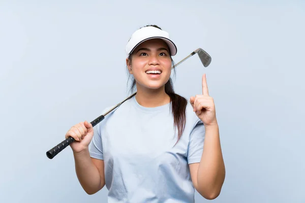 若いゴルファーアジアの女の子は 指を持ち上げながら解決策を実現しようとする孤立した青い背景の上に — ストック写真