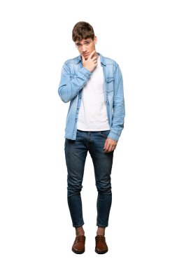 İzole beyaz arka plan üzerinde düşünen yakışıklı bir genç adamın tam uzunlukta bir çekim