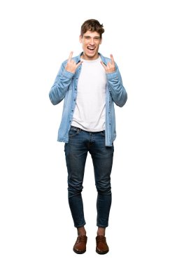 İzole beyaz arka plan üzerinde rock jest yapan yakışıklı bir genç adam tam uzunlukta bir çekim