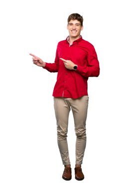İzole beyaz arka plan üzerinde yan parmak işaret Yakışıklı bir genç adam tam uzunlukta bir çekim