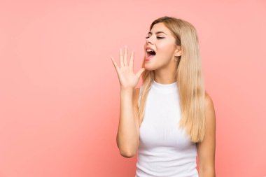Pembe arka planda genç bir kız ağzı açık bağırıyor.