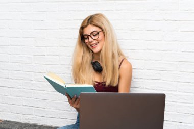 Genç kız dizüstü bilgisayarı ile katta oturan