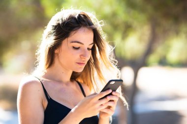 Cep telefonu kullanarak açık havada genç kız