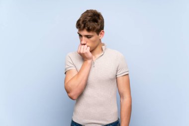 Izole mavi duvar üzerinde yakışıklı genç adam şüpheleri olan