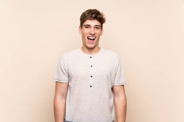 Sürpriz yüz ifade ile izole arka plan üzerinde yakışıklı genç adam