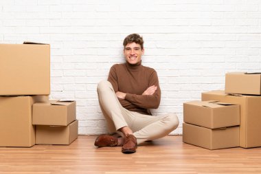 Yeni evinde kutular arasında dolaşan yakışıklı genç adam gülüyor