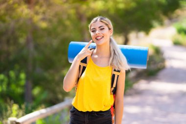 Genç kız mutlu ve hoş bir ifade ile gülümseyerek açık havada yürüyüş