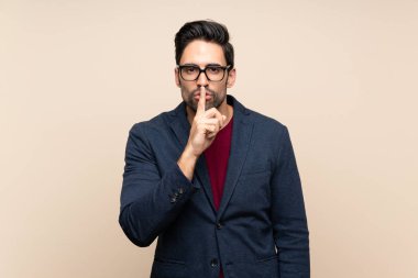 Sessiz jest ağzına parmak koyarak bir işareti gösteren izole arka plan üzerinde yakışıklı genç adam