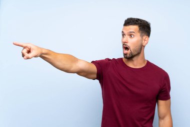 İzole edilmiş mavi arka planda yakışıklı bir adam.