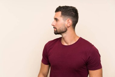 Izole arka plan üzerinde yakışıklı adam yan bakıyor