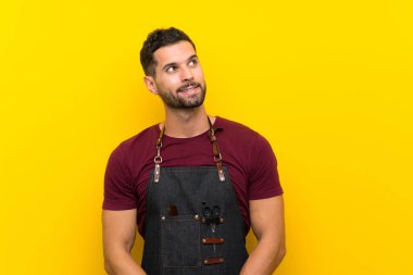 Bir önlük içinde Berber adam gülüyor ve yukarı bakıyor