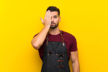 Bir önlük içinde Berber adam elle bir göz kapsayan