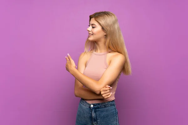 Adolescente Chica Sobre Aislado Púrpura Fondo Apuntando Hacia Atrás — Foto de Stock