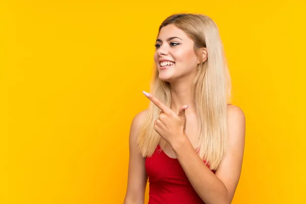 Adolescente Chica Sobre Aislado Amarillo Fondo Apuntando Dedo Lado —  Fotos de Stock