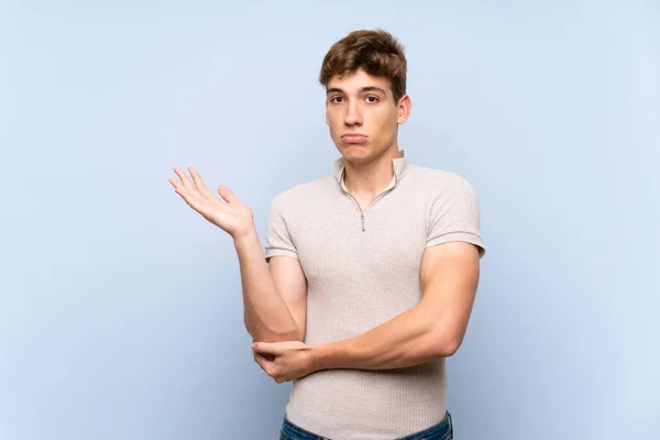 Guapo Joven Sobre Aislada Pared Azul Infeliz Por Entender Algo —  Fotos de Stock