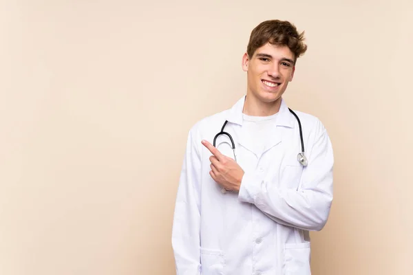 Bonito Médico Jovem Sobre Parede Isolada Apontando Para Lado Para — Fotografia de Stock