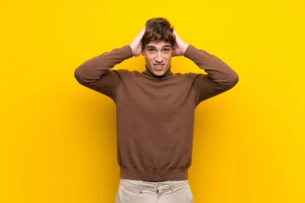 Handsome young man over isolated yellow background with surprise expression