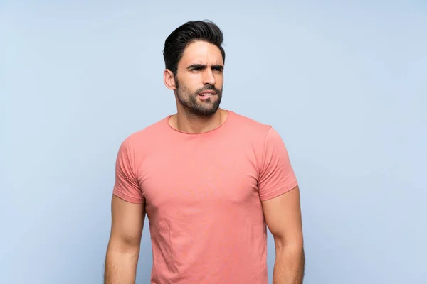 Knappe Jonge Man Roze Shirt Geïsoleerde Blauwe Achtergrond Met Verwarring — Stockfoto