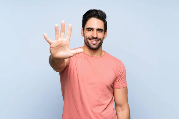 Knappe Jonge Man Roze Shirt Geïsoleerde Blauwe Achtergrond Tellen Vijf — Stockfoto