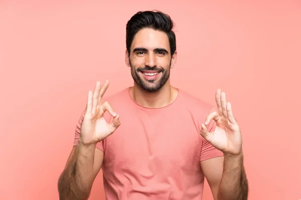 Joven Guapo Sobre Fondo Rosa Aislado Mostrando Signo Aceptable Con — Foto de Stock