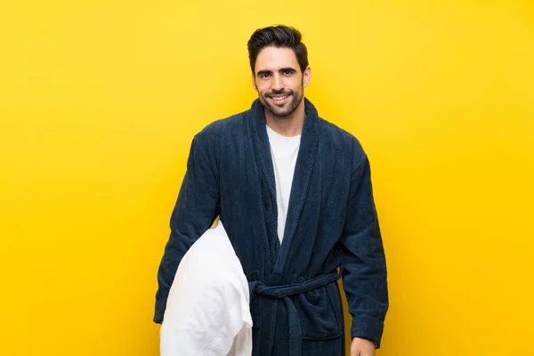 孤立した黄色の壁の上にパジャマのハンサムな男 — ストック写真