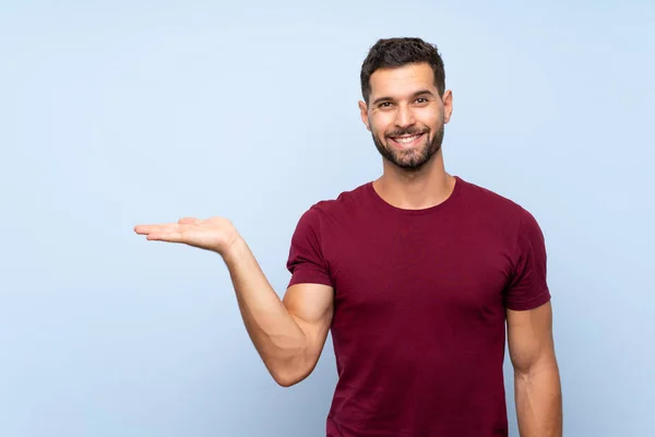 Knappe Man Geïsoleerde Blauwe Achtergrond Met Denkbeeldige Copyspace Palm Een — Stockfoto