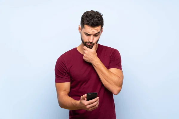 Hombre Guapo Sobre Fondo Azul Aislado Pensando Enviando Mensaje —  Fotos de Stock