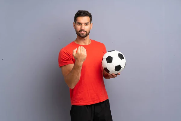 Stock image Handsome young football player man over isolated white wall inviting to come with hand. Happy that you came