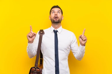 İşaret parmağı ile işaret izole sarı arka plan üzerinde Yakışıklı işadamı harika bir fikir