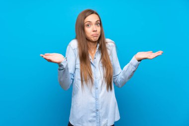 Izole mavi arka plan üzerinde genç kadın şüphe jest yapma