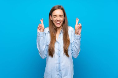 Parmak geçişi ile izole mavi arka plan üzerinde genç kadın