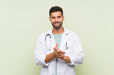 Izole yeşil duvar üzerinde genç doktor adam alkışlıyor