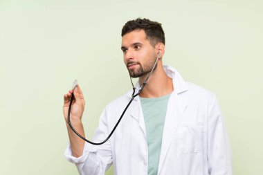 Izole yeşil duvar üzerinde genç doktor adam