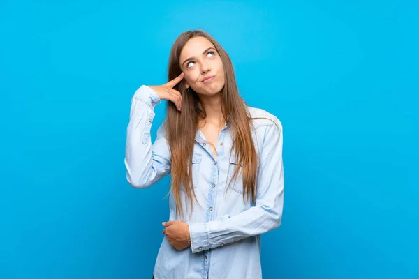 Ung Kvinna Över Isolerad Blå Bakgrund Gör Gest Galenskap Sätta — Stockfoto