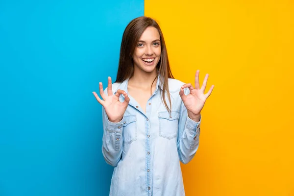 Renkli Arka Plan Üzerinde Genç Kadın Parmakları Ile Işareti Gösteren — Stok fotoğraf