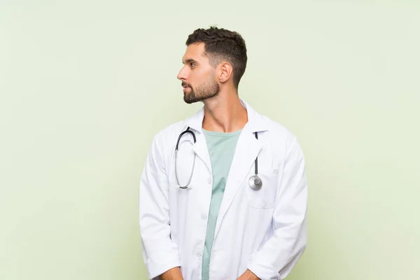 Giovane Medico Uomo Oltre Isolato Muro Verde Guardando Lato — Foto Stock