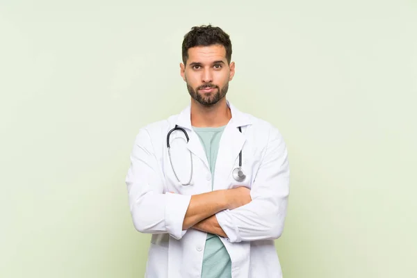 Giovane Medico Uomo Oltre Isolato Muro Verde Tenendo Braccia Incrociate — Foto Stock