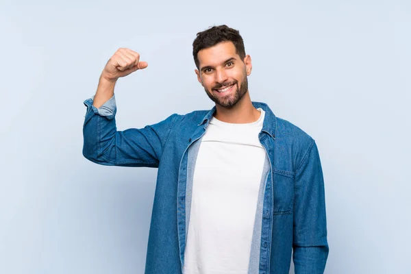 Hombre Guapo Sobre Fondo Azul Aislado Haciendo Gesto Fuerte — Foto de Stock