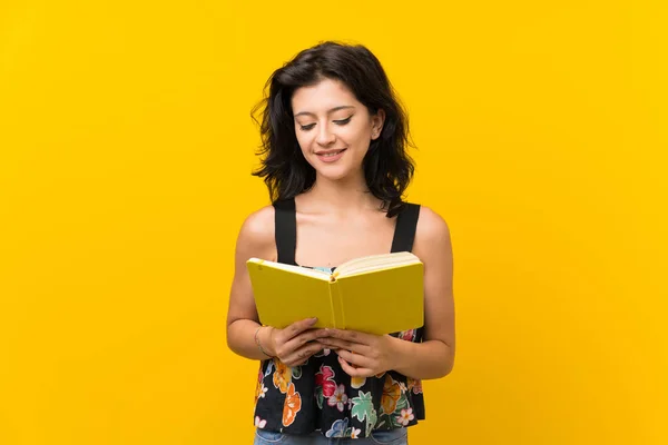 Junge Frau Vor Isoliertem Gelben Hintergrund Die Ein Buch Hält — Stockfoto
