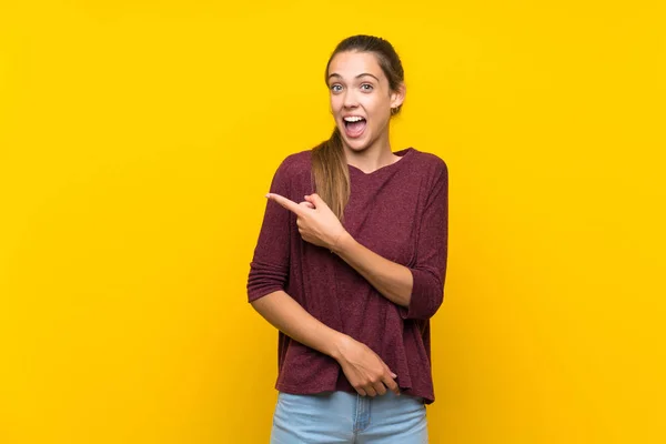 Mujer Joven Sobre Fondo Amarillo Aislado Sorprendido Apuntando Lado — Foto de Stock