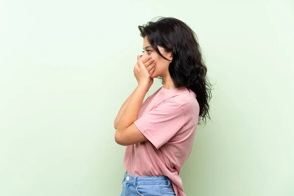 Jovem Mulher Sobre Fundo Verde Isolado Cobrindo Boca Olhando Para — Fotografia de Stock