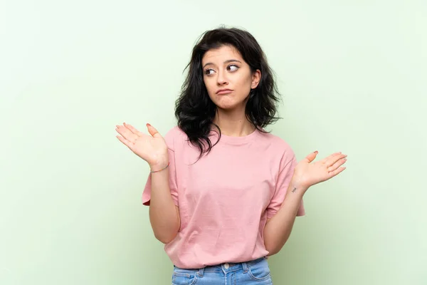 Giovane Donna Sfondo Verde Isolato Facendo Dubbi Gesto — Foto Stock