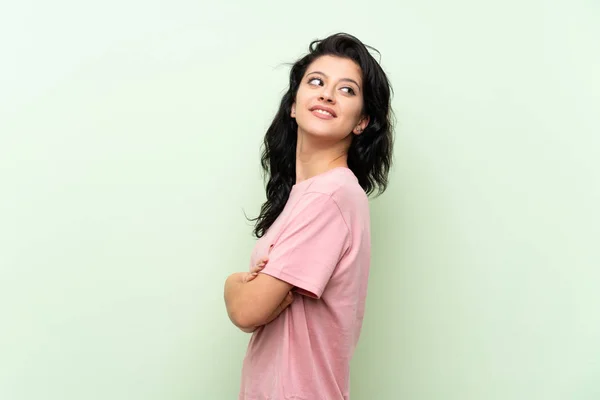 Young Woman Isolated Green Background Arms Crossed Happy — Stock Photo, Image
