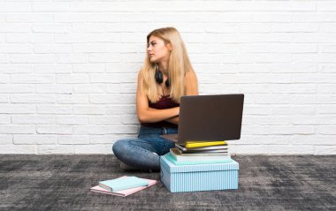 Genç kız onun laptop portre ile katta oturan