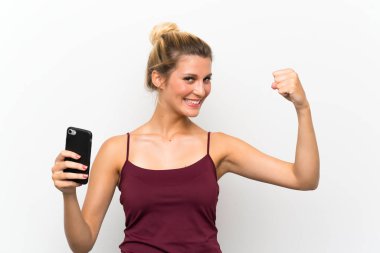 Zaferi kutlayan cep telefonu kullanan genç sarışın kadın